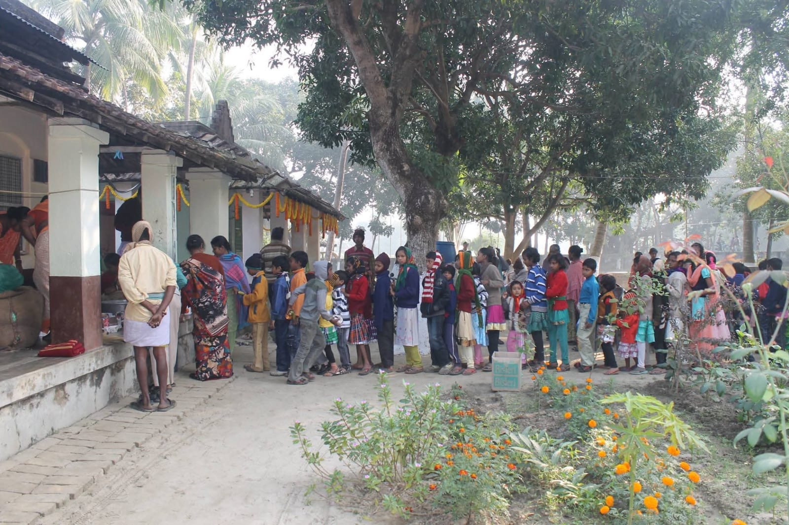 Women and community members waiting near the Ashram campus